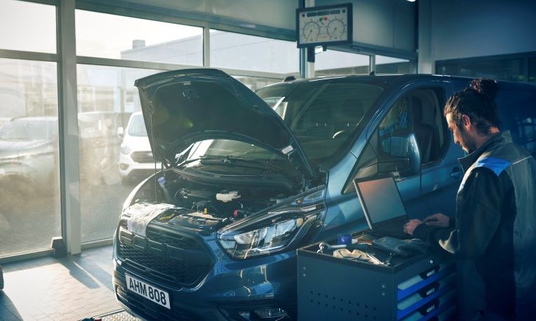 Ford technician with laptop next to a Ford Transit Custom